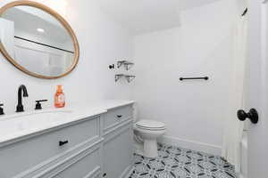 Bathroom with vanity, light tile patterned floors, and shower / tub combo with curtain