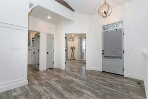 Foyer featuring wood finished floors and a chandelier