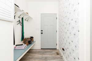 Mudroom featuring light wood-style flooring and baseboards