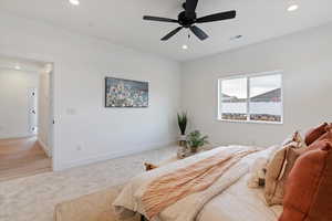Bedroom featuring light colored carpet, ceiling fan, and recessed lighting