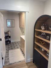 Photos are of staged model home.  Laundry area featuring cabinet space and dark wood-type flooring in mud room