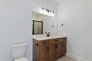 Full bathroom featuring vanity, light tile patterned flooring, and a shower stall