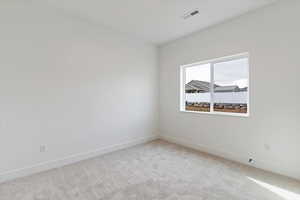 Empty room featuring light colored carpet and baseboards