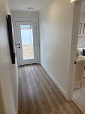 Photos are of staged model home.  Back Doorway with baseboards and wood finished floors