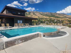 Community pool with a patio area and a mountain view