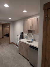 Kitchen featuring light carpet, stainless steel dishwasher, recessed lighting, and light stone counters