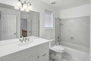 Full bathroom with vanity, washtub / shower combination, and marble finish flooring