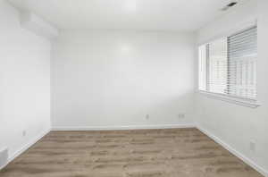 Unfurnished room with wood finished floors and baseboards