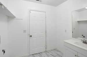 Bathroom with light marble finish floors and vanity