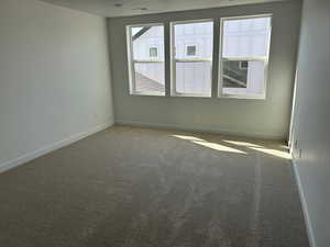 Spare room with carpet and baseboards