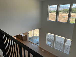 Stairway featuring wood finished floors and a high ceiling