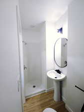 Bathroom with a stall shower and light wood-style floors