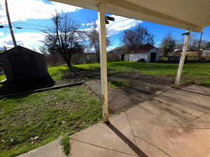 Fenced backyard featuring a storage shed and a patio