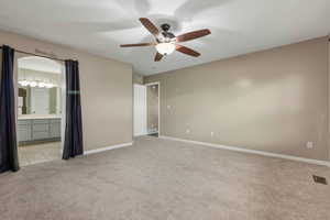 Unfurnished bedroom with light carpet, ceiling fan, and connected bathroom