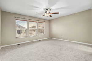 Spare room featuring light carpet and ceiling fan