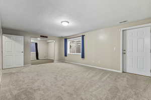Spare room featuring a textured ceiling and carpet