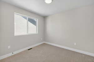 Carpeted empty room featuring baseboards