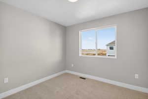 Carpeted spare room with baseboards