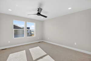 Spare room featuring carpet flooring, ceiling fan, and recessed lighting