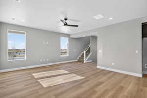 Unfurnished room featuring light wood-style flooring, stairway, a ceiling fan, and recessed lighting