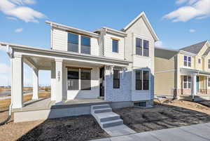 View of front of property with covered porch and brick siding