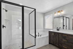 Bathroom with a garden tub, vanity, tile patterned floors, a shower stall, and a textured ceiling