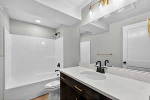 Bathroom featuring  shower combination, vanity, and light wood-style floors