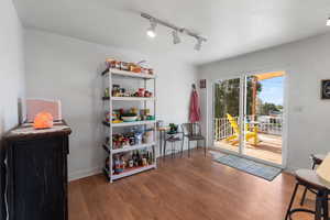 Living area featuring rail lighting and wood finished floors