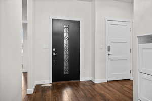 Entryway featuring baseboards and dark wood-style flooring