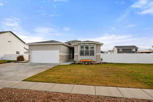 View of front facade featuring stucco siding, a garage, driveway, and stone siding