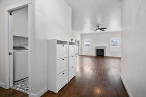 Corridor with washer / dryer and dark wood finished floors