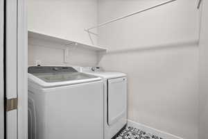 Laundry room with baseboards and washing machine and dryer