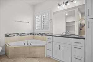 Bathroom featuring a bath, vanity, light tile patterned flooring, and a shower stall