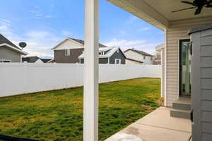 Fenced backyard featuring a ceiling fan and a patio