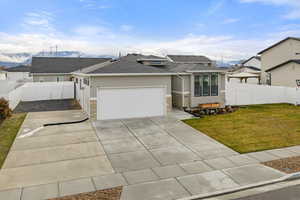 View of front facade featuring a fenced backyard, stucco siding, concrete driveway, roof with shingles, and a garage