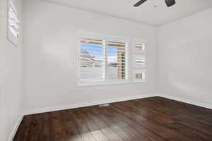Spare room with baseboards and dark wood-style flooring