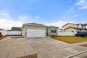 View of front facade with stucco siding, driveway, and an attached garage