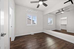 Spare room featuring dark wood finished floors and baseboards
