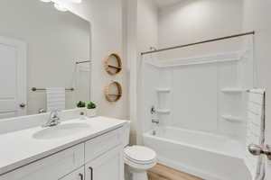 Full bath with vanity, bathing tub / shower combination, and light wood-style floors