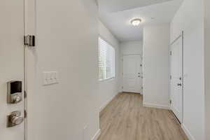 Hall with baseboards and light wood-type flooring