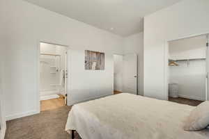 Bedroom featuring light colored carpet, a closet, and connected bathroom