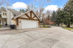 View of side of property featuring driveway, stucco siding, and roof with shingles