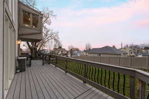 Deck at dusk with a residential view and a fenced backyard