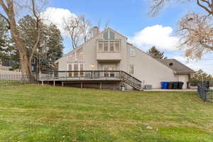 Back of house with stucco siding, a deck, a chimney, a patio area, and stairway