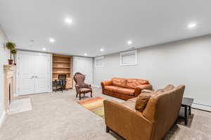 Living room with an office area, recessed lighting, light carpet, and a baseboard heating unit
