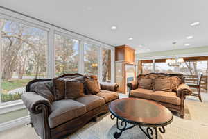 Living room featuring light colored carpet, recessed lighting, and a chandelier
