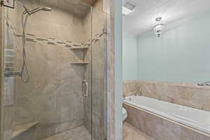 Full bath featuring a garden tub, a stall shower, a textured ceiling, and tile patterned floors