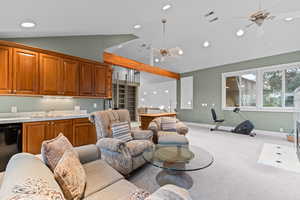 Living room with light colored carpet, a ceiling fan, recessed lighting, and high vaulted ceiling