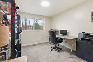 Office area with baseboards and light carpet