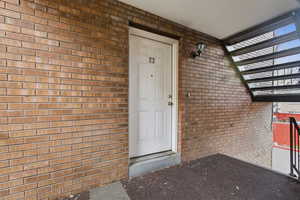 Doorway to property featuring brick siding